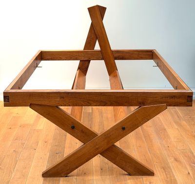 a wooden table with a glass top sitting on a hard wood floor