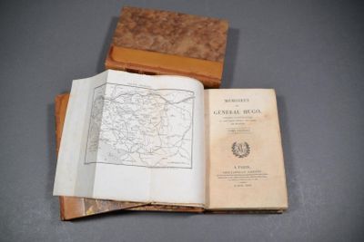 un livre ouvert posé sur une table à côté d'un livre