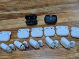 a lot of white airpods sitting on a wooden table