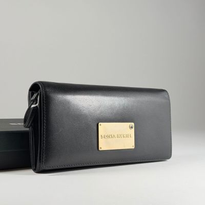 un portefeuille en cuir noir orné d'une plaque dorée sur le devant