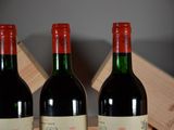 three bottles of red wine sitting on a table