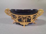 a black bowl with gold decoration on it on a table
