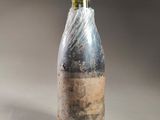 a bottle of wine wrapped in plastic on a table