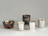quatre coupes en argent et une coupe en argent posée sur un fond blanc