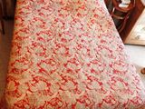 un lit recouvert d'une couette rouge et blanche