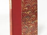 a book with a red cover sitting on top of a white surface