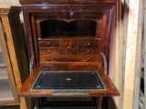 une armoire en bois avec un plateau en cuir noir