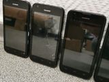 four cell phones are sitting next to each other on the floor