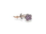 un gros plan sur une paire de boucles d'oreilles ornées de pierres violettes