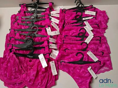 Plusieurs paires de maillots de bain roses sont exposées dans un magasin.