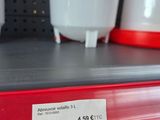 a red shelf with a white cup on it and a red cup on the shelf