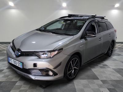 La Toyota Corollant est garée dans une grande pièce au sol carrelé en damier.