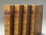 trois vieux livres posés l'un sur l'autre sur une table
