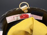 a yellow hat with a tag on it sitting in a pan