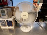un ventilateur blanc posé sur une table en métal