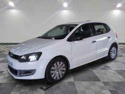 the white volkswagen polo is parked on a checkered tile floor
