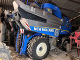 a blue tractor that is parked inside of a building