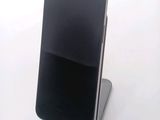 a black cell phone sitting on a stand on a table