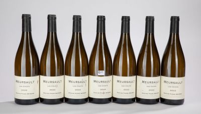 six bottles of wine are lined up in a row on a table