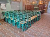 tables and chairs are arranged in a row in a restaurant