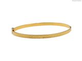 un bracelet rigide en or au motif texturé
