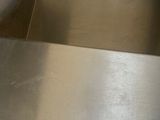 a metal shelf that has a metal tray on top of it