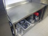 un plan de travail en acier inoxydable sur lequel sont posés des casseroles et des poêles