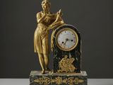 une statue de femme tenant une horloge sur une table