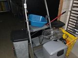 une photo d'une pièce avec une machine à laver et une poubelle