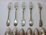 five forks and six spoons on a white table