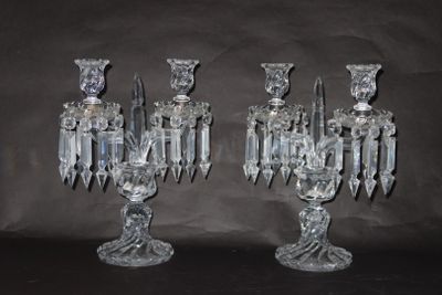 une paire de bougeoirs en cristal transparent sur fond noir