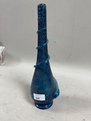 une bouteille en verre bleue sur laquelle est collée une étiquette