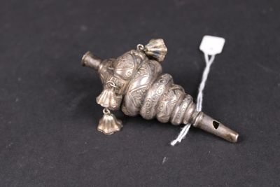 un vieil objet métallique argenté, avec un fil blanc sur une surface noire