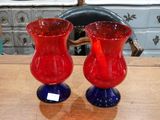 deux vases rouges et bleus posés sur une table en bois