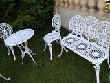 trois chaises blanches et une table dans le jardin