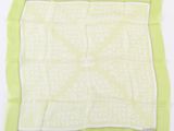 green and white square scarf with words printed on it