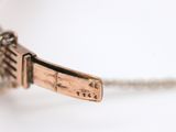 a close up of a necklace on a white surface