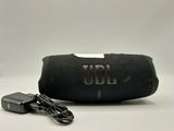 the jbl charger is plugged into the case and plugged into the charger