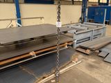 steel plates are stacked on pallets in a warehouse