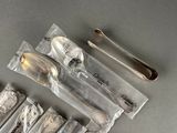 five silver spoons and two silver spoons on a table