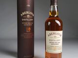 a bottle of whisky next to a cardboard box on a table