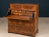 an old wooden desk with drawers and a phone on top of it