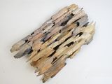un morceau de bois flotté posé sur une surface blanche