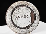 a white plate with black writing on it sitting on a table