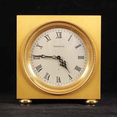 une horloge en or avec des chiffres romains sur le cadran