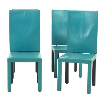 une paire de chaises de salle à manger en cuir turquoise avec des pieds noirs