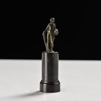 statue d'un homme tenant un ballon de basket sur un socle noir