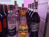 bottles of alcohol are lined up on a shelf in a bar