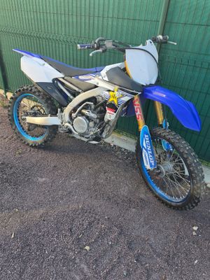 une moto tout-terrain bleue et blanche garée sur le bord de la route