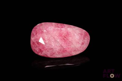 un quartz rose posé sur une surface noire